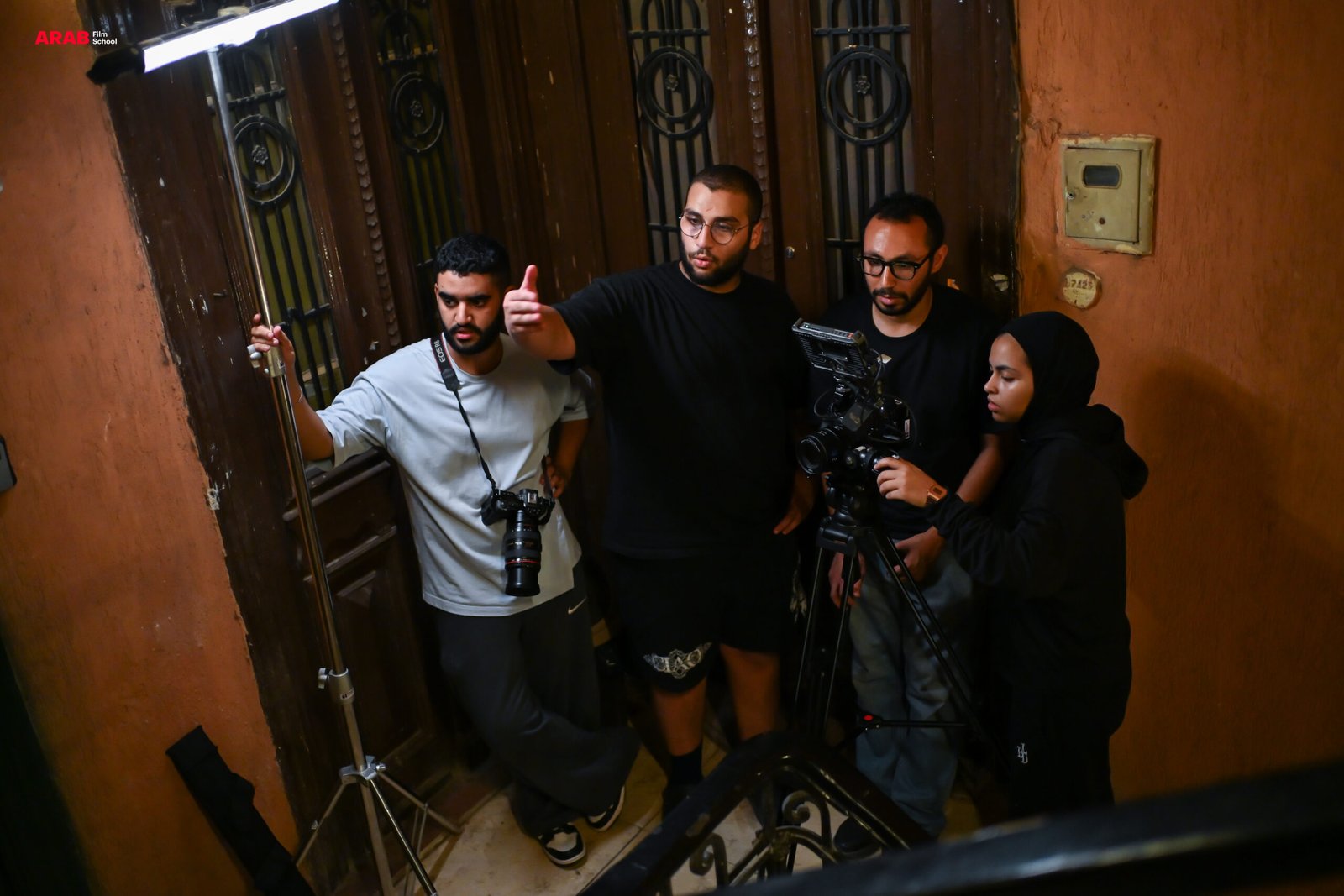 مخرج يوجّه فريق التصوير بجوار الكاميرا أثناء تصوير مشهد